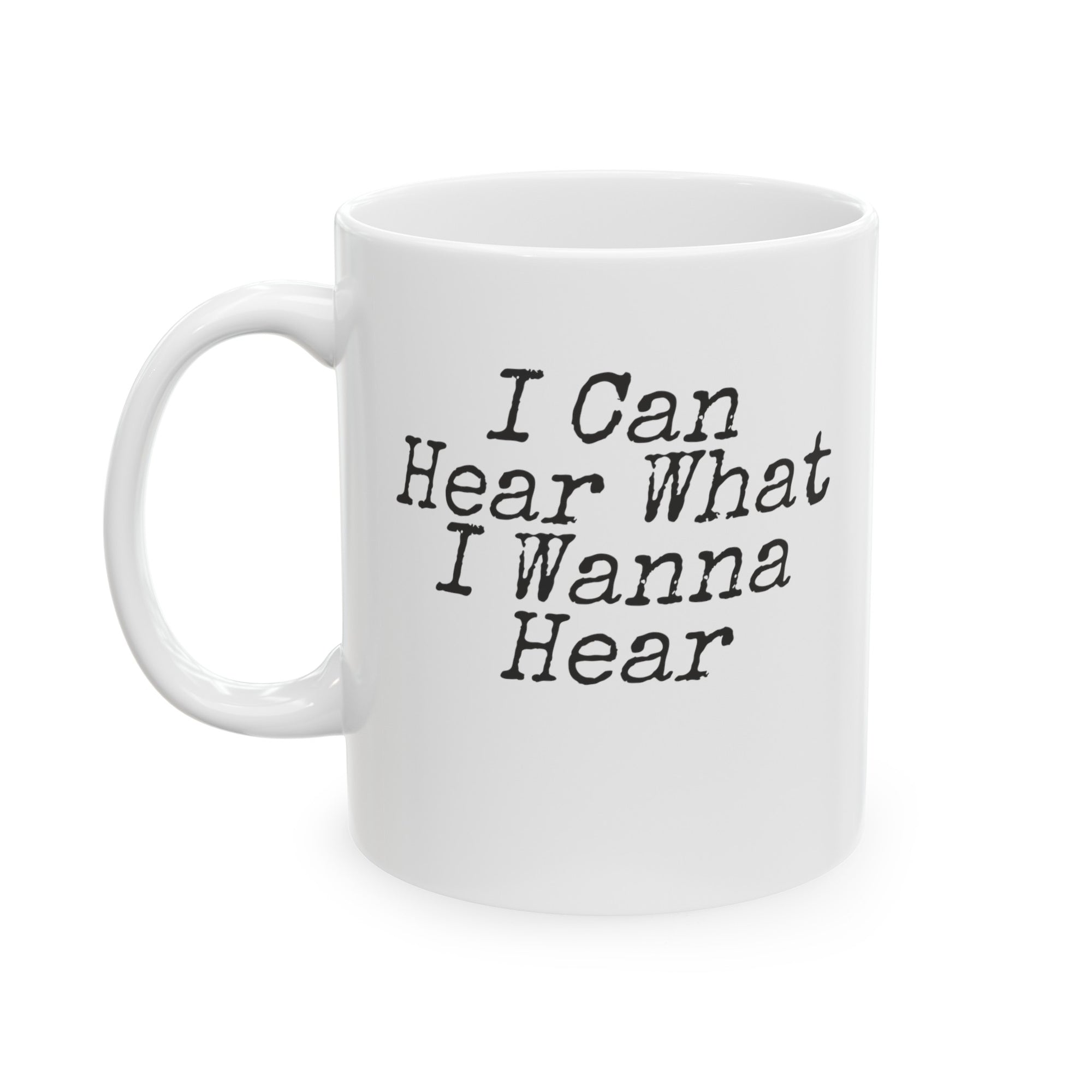 A white ceramic coffee mug featuring the humorous phrase 'I Can Hear What I Wanna Hear' in bold white text. The mug is designed with a comfortable grip and is perfect for coffee and tea lovers, especially those with hearing loss. The unique design adds a touch of humor and personality to your morning routine.